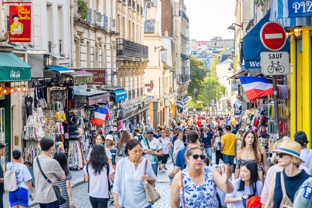 Crowd of tourists walking in a shopping street of Montmartre district in Paris France