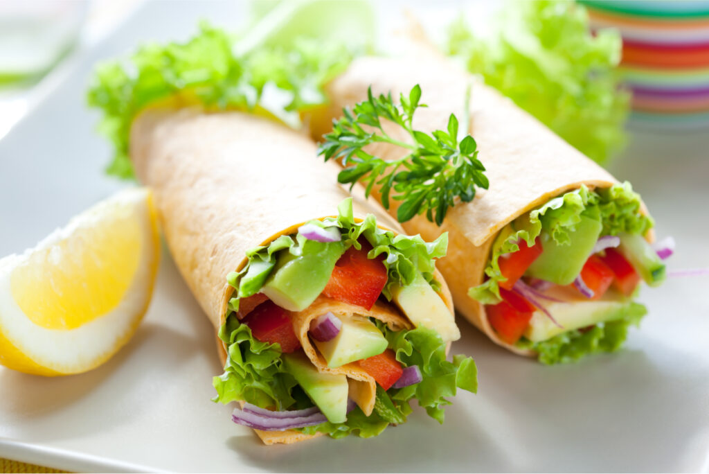 Two healthy veggie wraps full of uncooked vegetables