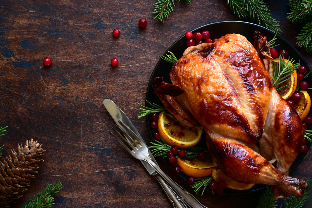 Roasted Turkey with oranges ,rosemary and cranberries on a christmas table. Top view with copy space. Referring to the thanksgiving food.