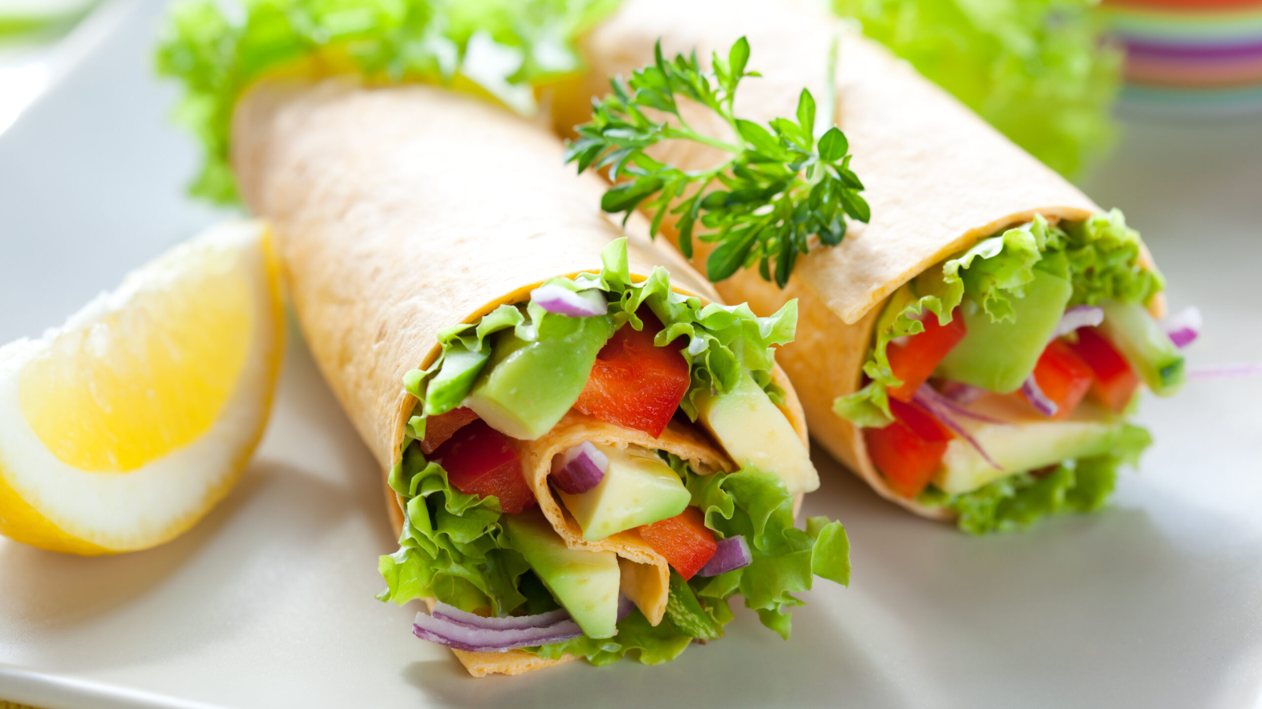 Two healthy veggie wraps full of uncooked vegetables