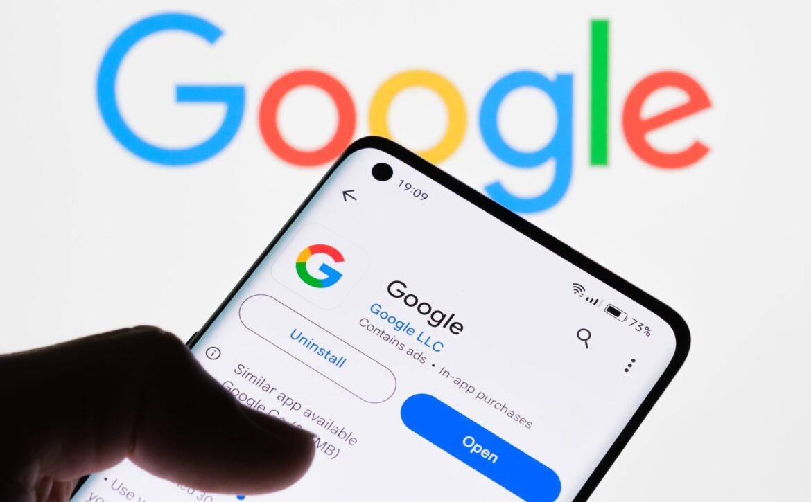 Close-up of a smartphone screen displaying Google app with Google logo in the background, demonstrating the connection between Google app and website search rankings