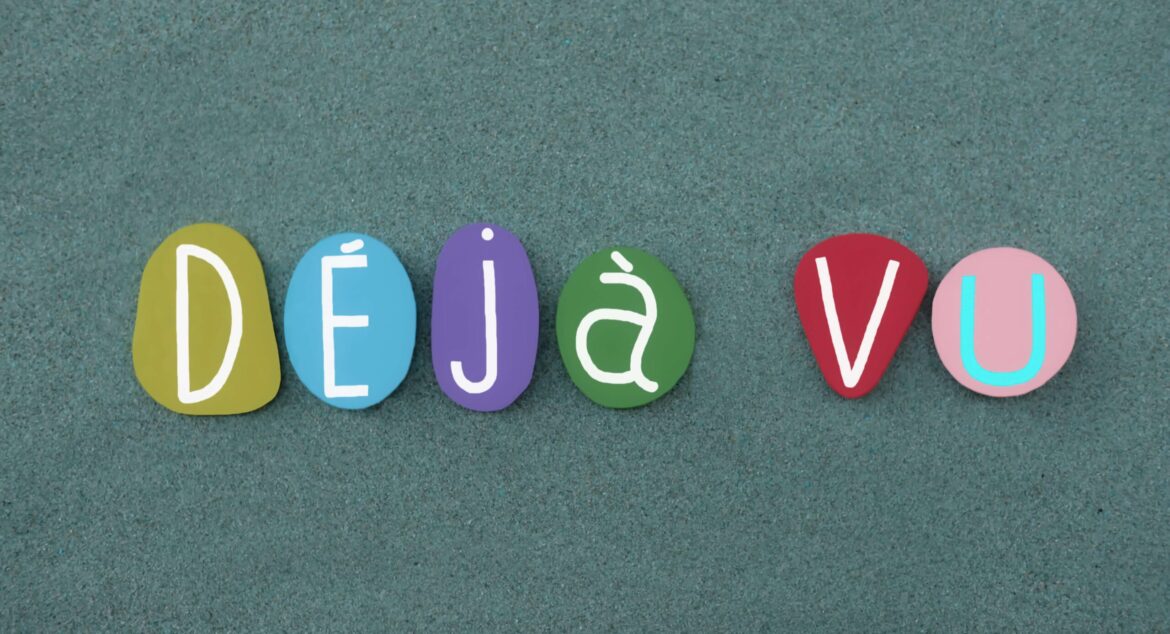 Deja vu, neurological anomaly text composed with multi colored stone letters over green sand